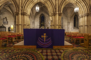 An altar with purple altar cloth in the centre of the cathedral nave.